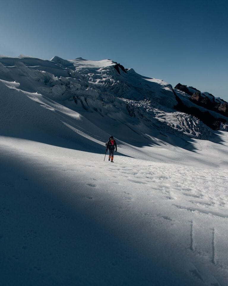 A person walking up a snow covered mountain